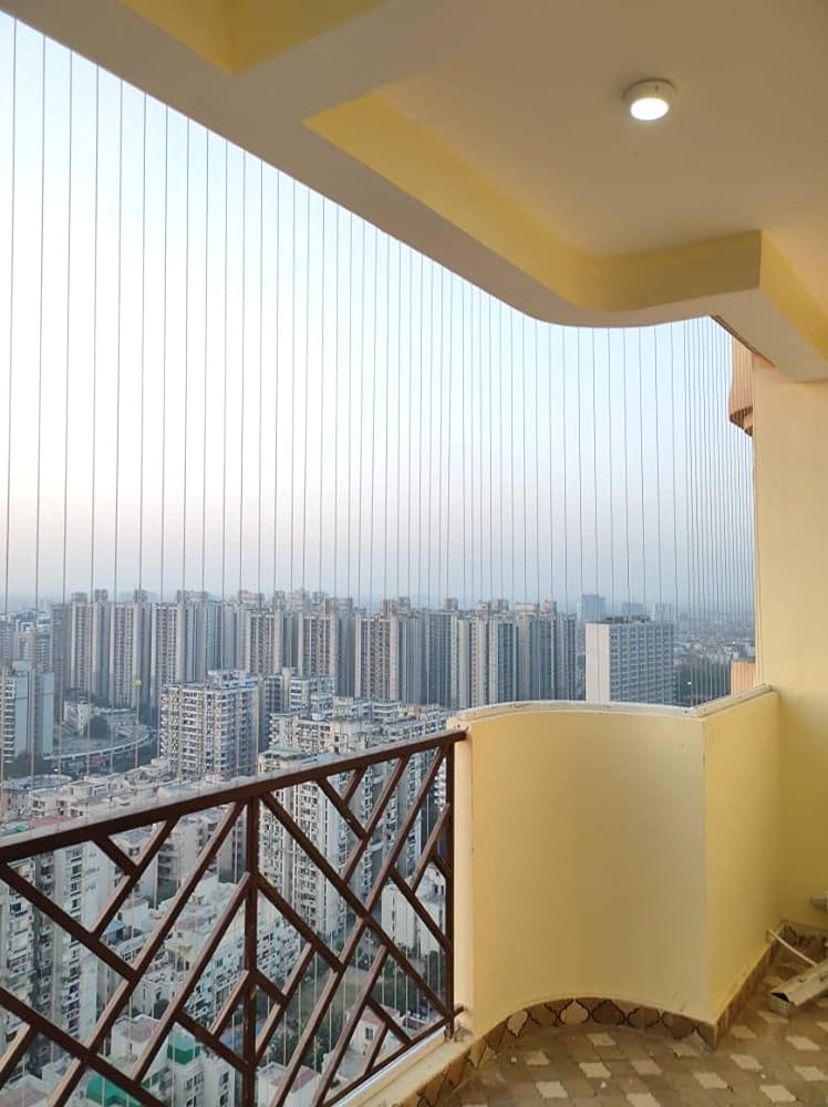 High-rise apartment balcony with invisible grill cables overlooking the city skyline