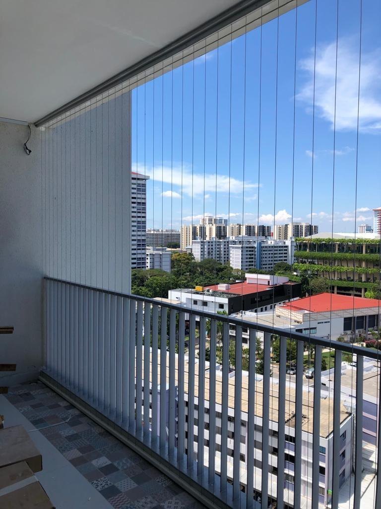 Apartment balcony with invisible grills and a clear view of nearby buildings